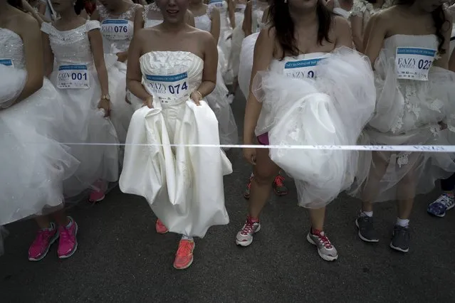 Brides-to-be get ready for the "Running of the Brides" race in a park in Bangkok, Thailand, November 28, 2015. (Photo by Athit Perawongmetha/Reuters)