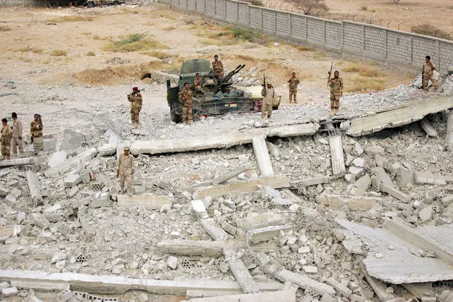 Yemeni soldiers stand on the ruins of a machine gun mounted on a truck at the site of a police barracks, which was bombed by al Qaeda insurgents, in al-Mahfad in the southern Yemeni province of Abyan May 23, 2014. (Photo by Khaled Abdullah/Reuters)