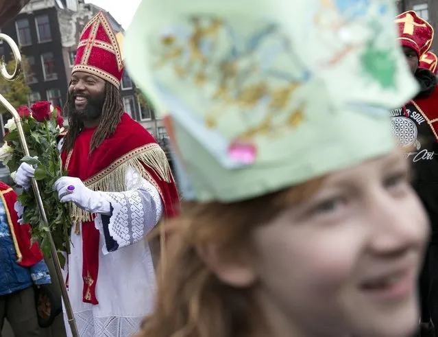 Sinterklaas, traditionally played by a white person, arrives in Amsterdam, Netherlands, Saturday, November 5, 2016. The steam boat carrying Sinterklaas, the Dutch equivalent of Santa Claus is not due to chug into the historic harbor of Maassluis until next weekend, but the annual polarized debate about his helper “Black Pete” has been underway for weeks. (Photo by Peter Dejong/AP Photo)