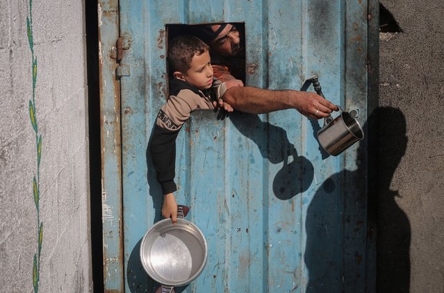 Displaced Palestinians wait for food at a shelter in Nuseirat, Gaza, on Sunday, November 23, 2025. (Photo by Eyad Baba/AFP Photo)