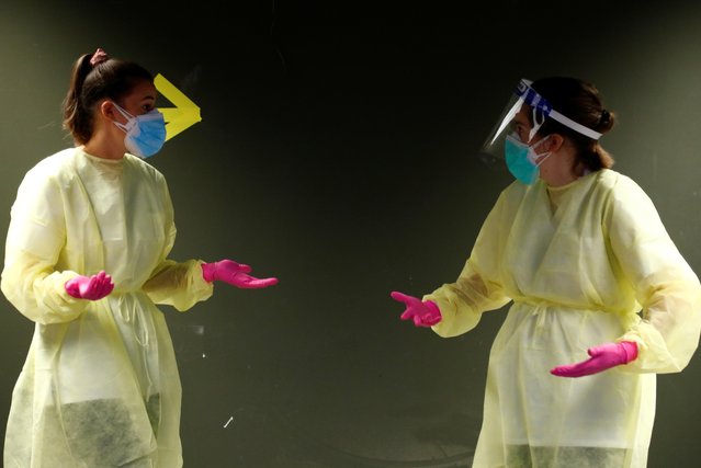 Nurses wearing protective suits and face masks talk at a testing site as the spread of the coronavirus disease (COVID-19) continues, in Brussels, Belgium on October 21, 2020. (Photo by Francois Lenoir/Reuters)