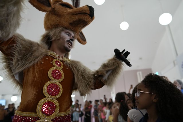 A person dressed as a reindeer sings for children being treated at the Children's Hospital during a Christmas event in Brasilia, Brazil, December 16, 2024. (Photo by Eraldo Peres/AP Photo)
