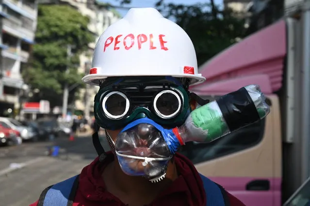 A protester wearing an improvised tear gas protection gear looks on during a demonstration against the military coup in Yangon on March 2, 2021. (Photo by AFP Photo/Stringer)