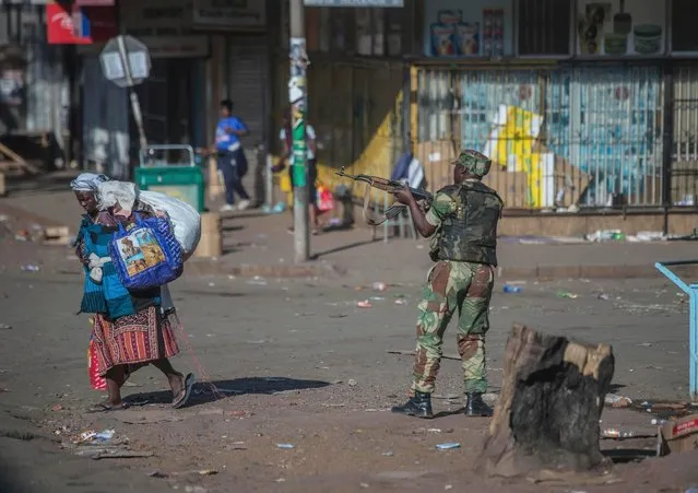 An armed soldier patrols a street in Harare during protests by opposition party supporters Wednesday, August 1, 2018. Hundreds of angry opposition supporters outside Zimbabwe's electoral commission were met by riot police firing tear gas as the country awaited the results of Monday's presidential election, the first after the fall of longtime leader Robert Mugabe. (Photo by Mujahid Safodien/AP Photo)