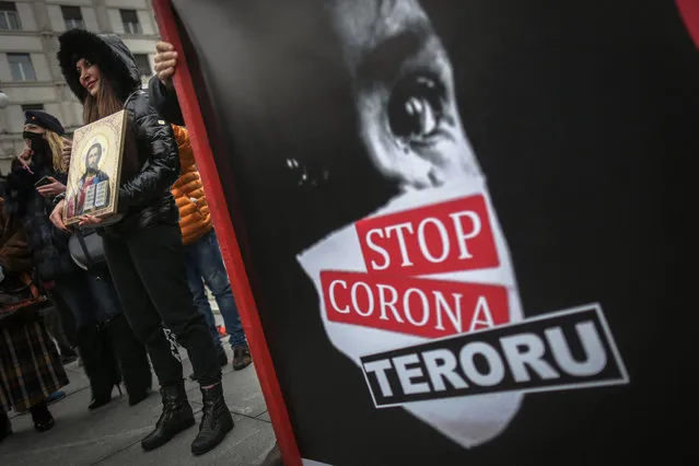 Protesters take part in a demonstration against the restrictions implemented to limit the spread of the Covid-19 pandemic, as a banner is reading “Stop to Corona terror”, in Belgrade, on March 20, 2021. (Photo by Oliver Bunic/AFP Photo)