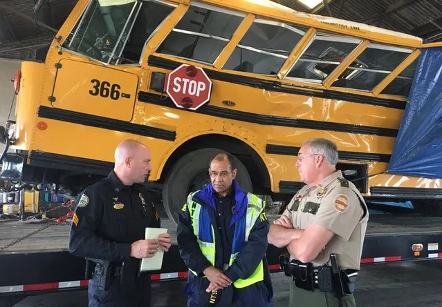 Christopher Hart (C), chairman of the National Transportation Safety Board, speaks with Chattanooga Police and Tennessee Highway Patrol officers while viewing the wreck of a school bus in which several children were killed, at a depot in Chattanooga, Tennessee, U.S. November 22, 2016. (Photo by Reuters/NTSB)
