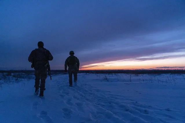 Ukrainian servicemen patrol an area after sunset near their position at the frontline near Vodiane, about 750 kilometers (468 miles) south-east of Kyiv, eastern Ukraine, Saturday, March 5, 2021. The country designated 14,000 doses of its first vaccine shipment for the military, especially those fighting Russia-backed separatists in the east. (Photo by Evgeniy Maloletka/AP Photo)