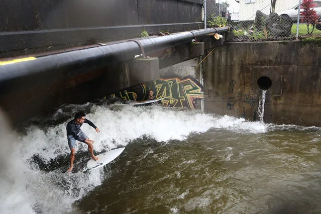Simon Carvalho surfs in a drainage canal swollen from Tropical Storm Lane rainfall, on the Big Island, on August 25, 2018 in Hilo, Hawaii. The three day rainfall total of 31.85 inches at Hilo International Airport during the former hurricane set a new record for Hilo. (Photo by Mario Tama/Getty Images)