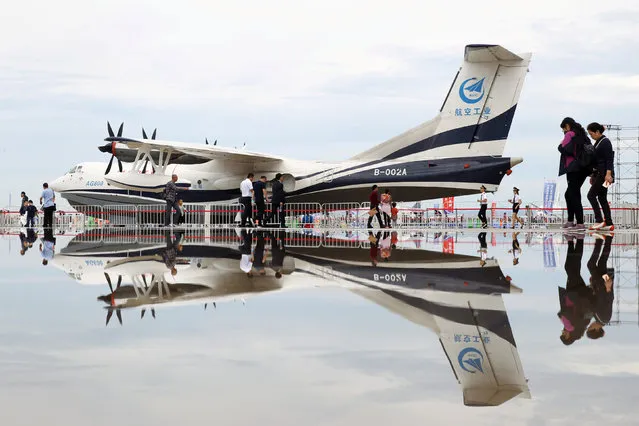 China's domestically developed AG600, the world largest amphibious aircraft, is seen reflected in a puddle at the Jing Men Aviclub Flight Carnival in Jingmen, Hubei province, China September 21, 2018. (Photo by Reuters/China Stringer Network)
