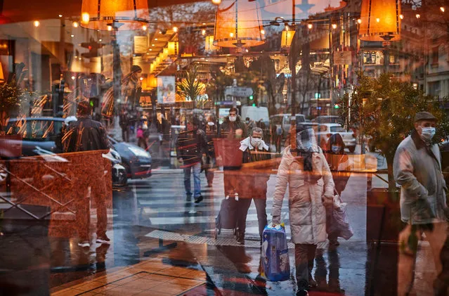 Parisians shoppers are reflected in a closed restaurant window as the French Government continues to try to contain it’s covid numbers and speed up the country's vaccine rollout as experts raise fears over new Covid strains spreading in France on January 12, 2021 in Paris, France. The French Government has come under criticism for its slow vaccine delivery, lagging far behind most Western countries. (Photo by Kiran Ridley/Getty Images)