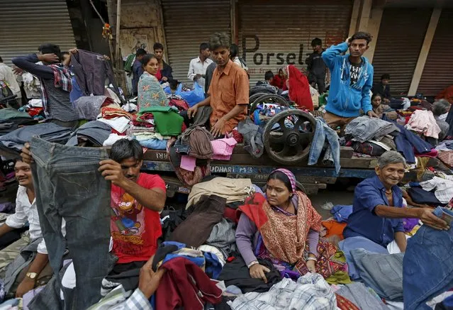 Vendors sell clothes at a second-hand street side clothing market in Mumbai, India, January 11, 2016. The market is open daily for three hours and hundreds of vendors gather to barter or sell used clothing. (Photo by Danish Siddiqui/Reuters)