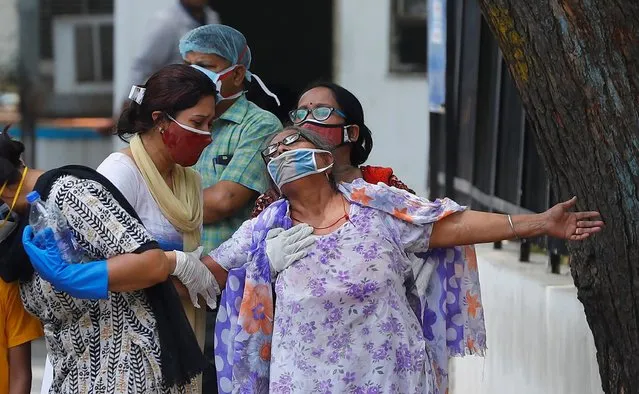 A woman mourns after seeing the body of her son who died due to the coronavirus disease (COVID-19), outside a mortuary of a COVID-19 hospital in New Delhi, India, May 12, 2021. (Photo by Adnan Abidi/Reuters)
