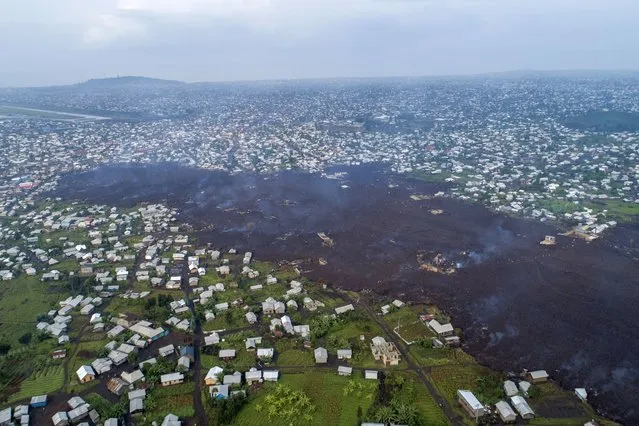 Lava from the eruption of Mount Nyiragongo cuts through Buhene north of Goma, Congo Monday, May 24, 2021. Residents returned to destroyed homes and searched for missing loved ones on the outskirts of Goma as officials called for vigilance amid small tremors after the large volcano erupted Saturday May 22, 2021 .  Mount Nyiragongo sent torrents of lava into villages after dark with little warning, leaving at least 15 people dead amid the chaos and destroying more than 500 homes. (Photo by Justin Kabumba/AP Photo)