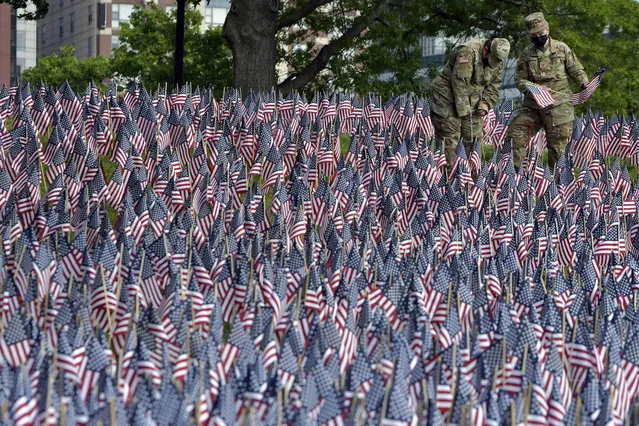 Master Sgt. Mark Radnick, and Capt. Ann Marie Leifer of the Mass. Air National Guard were among those planting American flags on Boston Common Wednesday, May 26, 2021, in Boston. Each year before Memorial Day weekend the Massachusetts Military Heroes Fund places a flag to represent every fallen member of the US military from Massachusetts since the Revolutionary War. (Photo by Josh Reynolds/AP Photo)