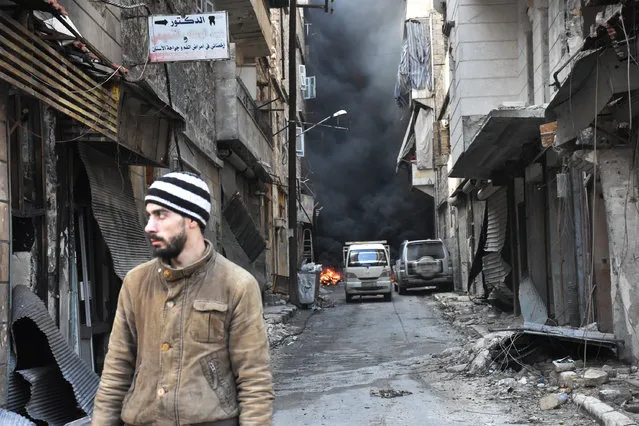 A Syrian man walks through the former rebel-held Salaheddin district in the northern Syrian city of Aleppo on December 23, 2016 after Syrian government forces retook control of the whole embattled city. Syrian troops cemented their hold on Aleppo after retaking full control of the city, as residents anxious to return to their homes moved through its ruined streets. (Photo by George Ourfalian/AFP Photo)