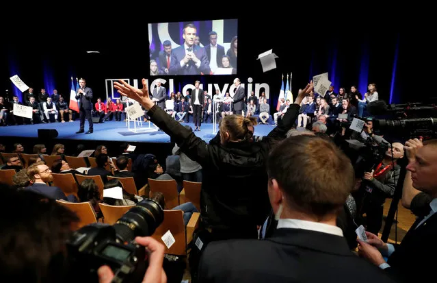 A protester throws papers denouncing Macron's politicies as French President Emmanuel Macron and Belgian Prime Minister Charles Michel take part in a conference at the UCL university in Louvain-La-Neuve, on the last day of an official state visit in Belgium, November 20, 2018. (Photo by Yves Herman/Reuters)