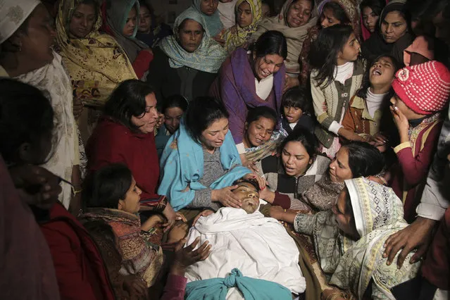 Pakistani women mourn the death of their family member in Toba Tek Singh, Pakistan, Wednesday, December 28, 2016. Local police officer Atif Imran Qureshi said that over two dozens people were killed and many transported to hospitals after they consumed contaminated alcohol during the Christmas holiday. (Photo by K.M. Chaudhry/AP Photo)