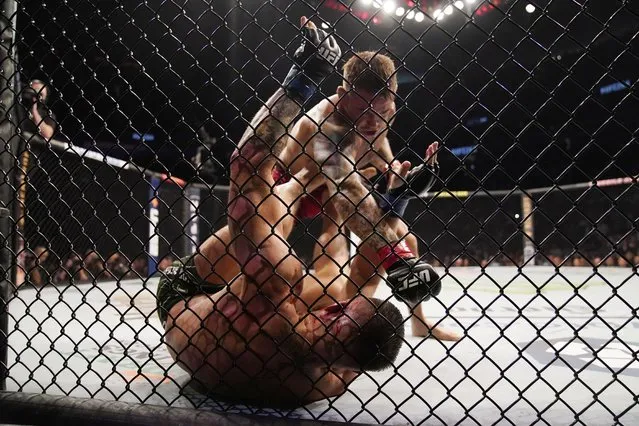 Dustin Poirier, top, punches Conor McGregor during a UFC 264 lightweight mixed martial arts bout Saturday, July 10, 2021, in Las Vegas. (Photo by John Locher/AP Photo)