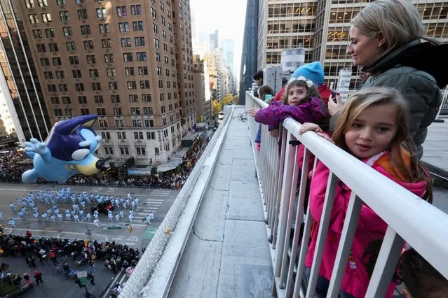Bluey balloon flies, as people watch the 95th Macy's Thanksgiving Day Parade, in Manhattan, New York City, U.S., November 23, 2023. (Photo by Brendan McDermid/Reuters)