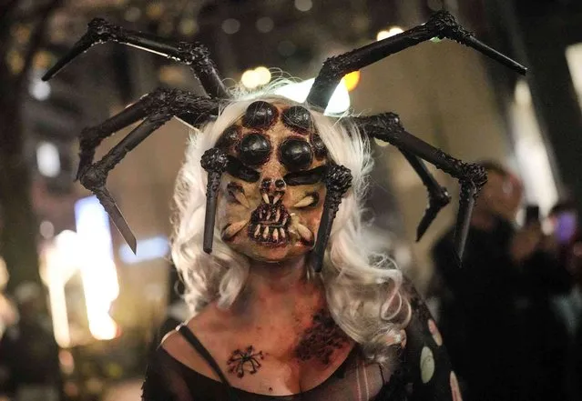 A woman is dressed up in a scary spider costume to participate in the annual Zombie Walk and Halloween Parade in Essen, Germany, Monday, October 31, 2022. (Photo by Martin Meissner/AP Photo)