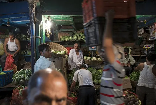 Vendors work at a wholesale vegetable and fruit market in Mumbai April 14, 2015. (Photo by Danish Siddiqui/Reuters)