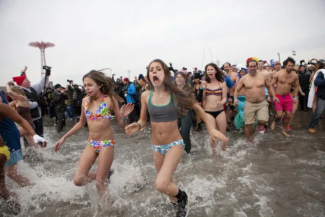 People participate in the annual Coney Island Polar Bear Club dip, in the Brooklyn borough of New York January 1, 2014. The Coney Island Polar Bear Club is the oldest winter bathing organization in the U.S. and every New Year's Day holds the winter plunge which attracts thousands of participants. (Photo by Allison Joyce/Reuters)