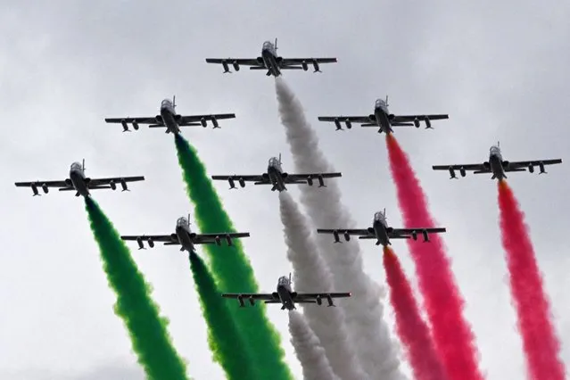 Planes of the Italian Air Force aerobatic unit Frecce Tricolori (Tricolor Arrows) spread smoke with the colors of the Italian flag as they fly over Rome on November 4, 2022 as part of celebrations of National Unity and Armed Forces Day, marking the end of the World War I in Italy. (Photo by Andreas Solaro/AFP Photo)
