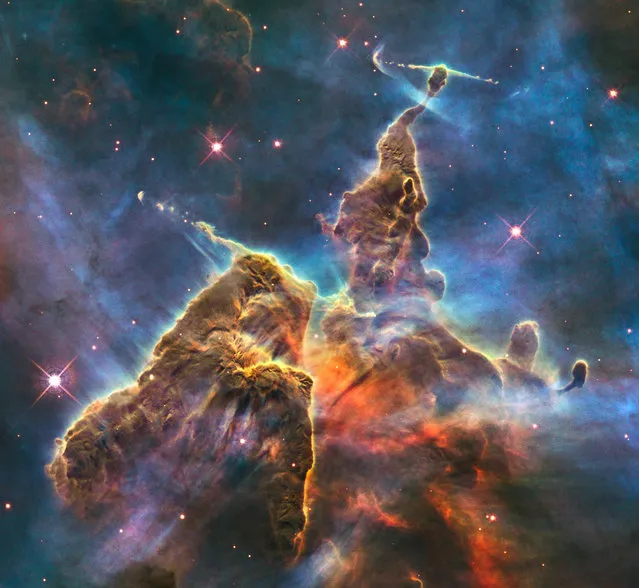 This February 2010 image made by the NASA/ESA Hubble Space Telescope shows a three-light-year-tall pillar of gas and dust in the Carina Nebula which is being eaten away by the light from nearby bright stars. Inside, infant stars fire off jets of gas that can be seen streaming from towering peaks. The stellar nursery is located 7500 light-years away in the southern constellation of Carina. (Photo by NASA/ESA, M. Livio, Hubble 20th Anniversary Team (STScI) via AP Photo)