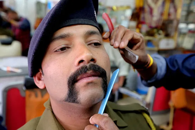 A barber gives customer Madhya Pradesh police officer Sanjeev Thapa (L) a mustache of patterned after the mustache of Indian Air Force (IAF) Wing Commander Abhinandan Varthaman, in Bhopal, India, 06 March 2019. Wing Commander Abhinandan Varthaman, who was released from Pakistan after being shot down during a conflict near Kashmir, has a unique moustache, which is in demand across the country, and some of the saloons are even giving it to customers for free. (Photo by Sanjeev Gupta/EPA/EFE)