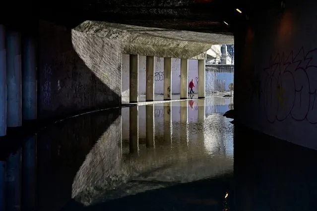 A child walks in a tunnel flooded by the Danube River in Budapest, Hungary on December 27, 2023. (Photo by Marton Monus/Reuters)