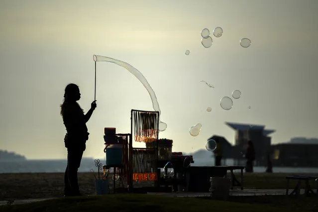 A vendor makes bubbles to attract customers at the Saujana Beach in Port Dickson on September 28, 2018. (Photo by Mohd Rasfan/AFP Photo)