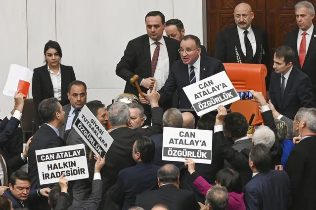 Turkish lawmakers, few holding up boards that read in Turkish: “Freedom for Can Atalay” argue with Parliament Deputy speaker Bekir Bozdag, top center, during a session at the Turkish parliament in Ankara, Tuesday, January 30, 2024. The Turkish Parliament stripped an imprisoned opposition lawmaker Can Atalay of his parliamentary status on Tuesday, defying a ruling made by the country's top court in September. Other boards read in Turkish: “Can Atalay. It's the will of the people”. (Photo by Mert Gokhan Koc/Dia Images via AP Photo)