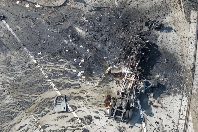 The tractor portion of a big rig is shown in an aerial view on Thursday, February 15, 2024, in the Wilmington section of Los Angeles. Several Los Angeles firefighters were injured, two critically, when an explosion occurred as they responded to a truck with pressurized cylinders that were on fire early Thursday, authorities said. (Photo by William Liang/AP Photo)