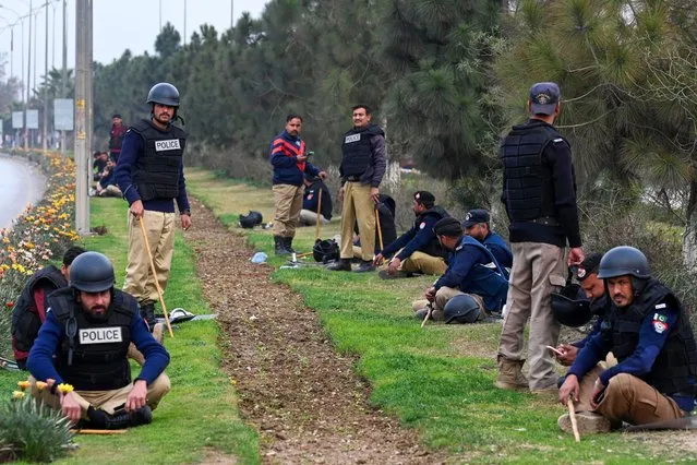 Police gather along a road while supporters of Khan's Pakistan Tehreek-e-Insaf (PTI) party block Peshawar to Islambad highway as they protest against the alleged skewing in Pakistan's national election results, in Peshawar on February 12, 2024. Police fired tear gas to disperse supporters of jailed former Pakistan prime minister Imran Khan on February 11 after his party urged protests outside election offices where they said rigging had taken place in last week's national vote. (Photo by Abdul Majeed/AFP Photo)