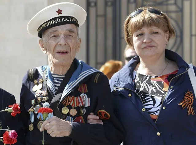 A World War Two veteran (L) arrives to watch the Victory Day parade at Red Square in Moscow, Russia, May 9, 2015. (Photo by Reuters/Host Photo Agency/RIA Novosti)