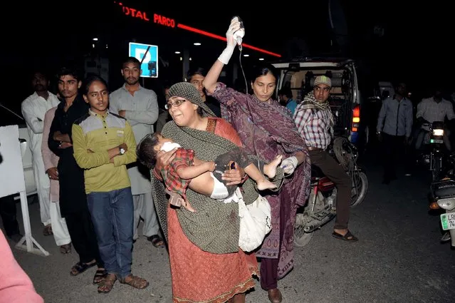 Pakistani relatives bring an injured child to the hospital in Lahore on March 27, 2016, after at least 56 people were killed and more than 200 injured when an apparent suicide bomb ripped through the parking lot of a crowded park in the Pakistani city of Lahore where Christians were celebrating Easter. (Photo by Arif Ali/AFP Photo)