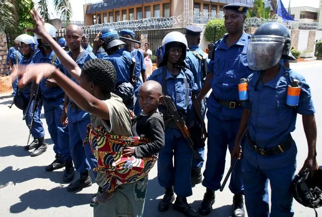 A woman dances as she carries her child in front of police during a protest by women against president Pierre Nkurunziza in Bujumbura, Burundi, May 10, 2015. (Photo by Goran Tomasevic/Reuters)