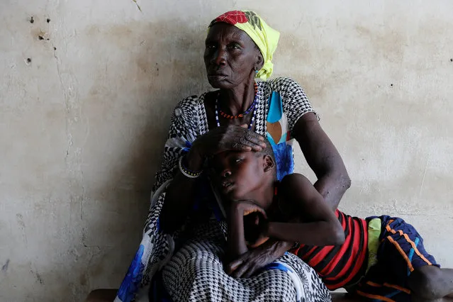 A woman comforts her son, who is suffering from malaria, as they wait for treatment at a Medecins Sans Frontieres (MSF) run clinic in the village of Likuangole, in Boma state, east South Sudan, February 1, 2017. (Photo by Siegfried Modola/Reuters)