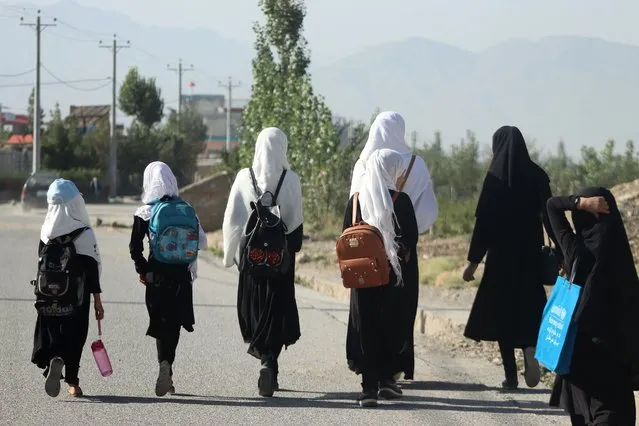 Afghan girls walk to their school along a road in Gardez, Paktia porvince, on September 8, 2022. Online classes helped ease the despair teenager Zainab felt after girls were shut out of secondary schools by Taliban authorities, but as male peers prepare for a new academic year she still feels left behind. (Photo by AFP Photo)