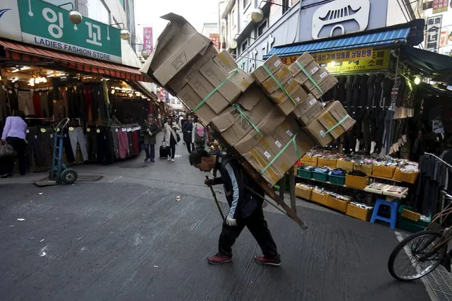 A worker carries stacks of boxes on his back at the Namdaemun Market in Seoul in this October 26, 2012 file photo. (Photo by Kim Hong-Ji/Reuters)