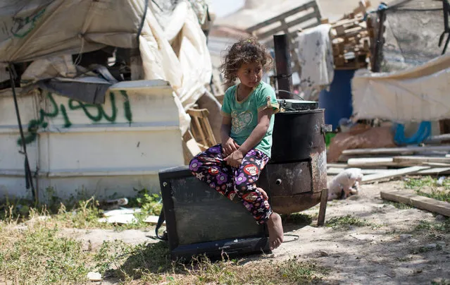 A Bedouin girl sits on a TV set saved from her damaged home after an Israeli bulldozer had demolished the house of the Dahouk family in the Bedouin community of Khan Al Ahmar, in the West Bank east of Jerusalem, 07 April 2016. Israeli authorities justified the demolishing by claiming that the homes have been illegally built on Israeli natural reserves land. (Photo by Atef Safadi/EPA)