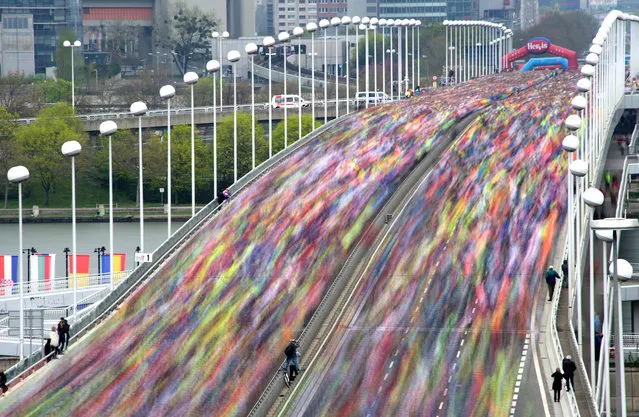 Thousands of runners are seen during a long exposure crossing the Reichsbrucke bridge over the Danube river, during the Vienna City Marathon in Vienna, Austria on April 10, 2016. This year, around 42 thousand participants were estimated to take part at the Vienna Marathon. (Photo by Joe Klamar/AFP Photo)