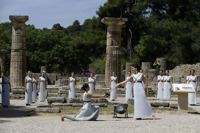 Actress Katerina Lehou, right, as high priestess, lights a pot with the Olympic Flame, during the final dress rehearsal of the lighting of the Olympic flame at Ancient Olympia, in western Greece on Wednesday, April 20, 2016. (Photo by Petros Giannakouris/AP Photo)