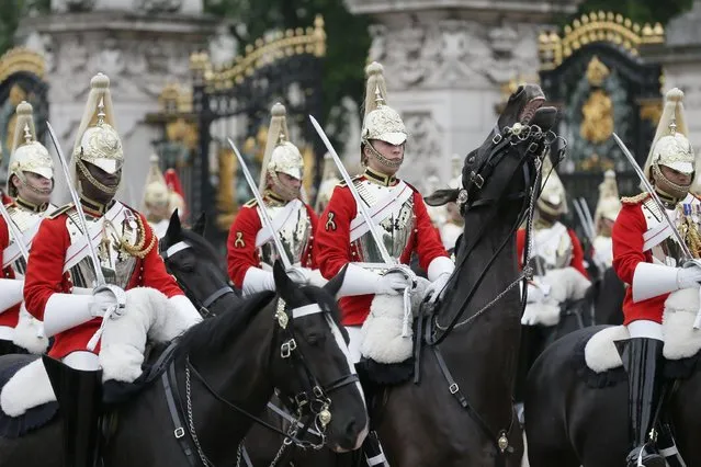 Soldiers of the Household Cavalry wait for the arrival of the carriages during the Trooping The Colour parade at Buckingham Palace, in London, Saturday, June 13, 2015. Hundreds of soldiers in ceremonial dress have marched in London in the annual Trooping the Color parade to mark the official birthday of Queen Elizabeth II. The Trooping the Color tradition originates from preparations for battle, when flags were carried or "trooped" down the rank for soldiers to see. (AP Photo/Tim Ireland)