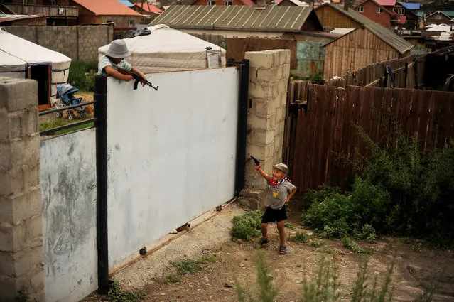 Two young boys run around and play with toy guns in the Ger District in Ulaanbaatar, Mongolia on July 28, 2012. Ger districts usually occupy poor quality land on the outskirts of town. (Photo by Master Sgt. Jeremy Lock/U.S. Air Force)