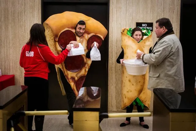 People dressed in food-themed costumes give away donuts to people headed to the floor of the New York Stock Exchange to celebrate the IPO of GrubHub, in New York April 4, 2014. (Photo by Lucas Jackson/Reuters)