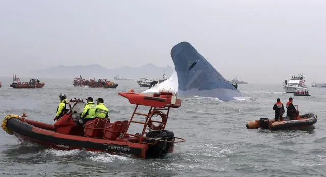Part of South Korean passenger ship “Sewol” that has been sinking is seen as South Korean maritime policemen search for passengers in the sea off Jindo April 16, 2014. (Photo by Hyung Min-woo/Reuters/Yonhap)