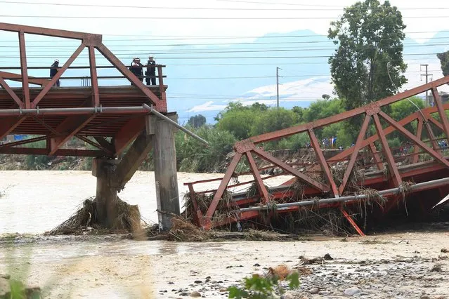 View of the Viru Bridge, which carries the Panamerican Highway between northern Peru and Lima, after it collapsed into the Viru River in the town of Viru due to the intense rains, cutting off supplies to the northern part of the country, on March 19, 2017. The El Nino climate phenomenon is causing muddy rivers to overflow along the entire Peruvian coast, isolating communities and neighbourhoods. Thousands have been affected since January, and 72 people have died. Most cities face water shortages as water lines have been compromised by mud and debris. (Photo by Celso Roldan/AFP Photo)