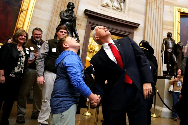 U.S. Vice President Mike Pence encourages a young tourist from Alabama, Mason Brasher, to look up at the Capitol rotunda as they cross paths as Pence departs following his meeting with Senate Republicans during their weekly policy luncheon at the U.S. Capitol in Washington, U.S. March 21, 2017. (Photo by Jonathan Ernst/Reuters)