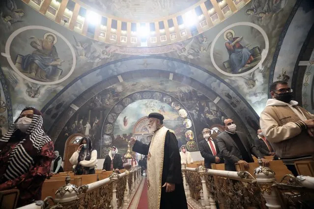 A Coptic priest prays during a Coptic Orthodox Christmas Eve mass at the Angel Mikhail church in Cairo, Egypt, 06 January 2022. (Photo by Khaled Elfiqi/EPA/EFE)